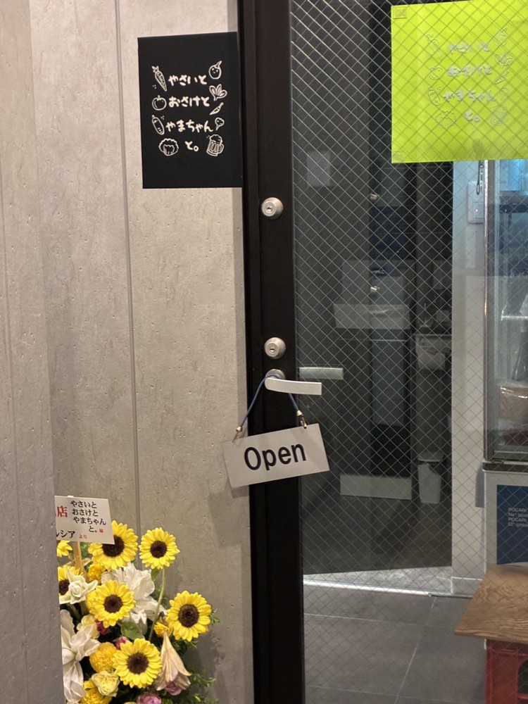 店の入口。黒い看板と「Open」の札が目印